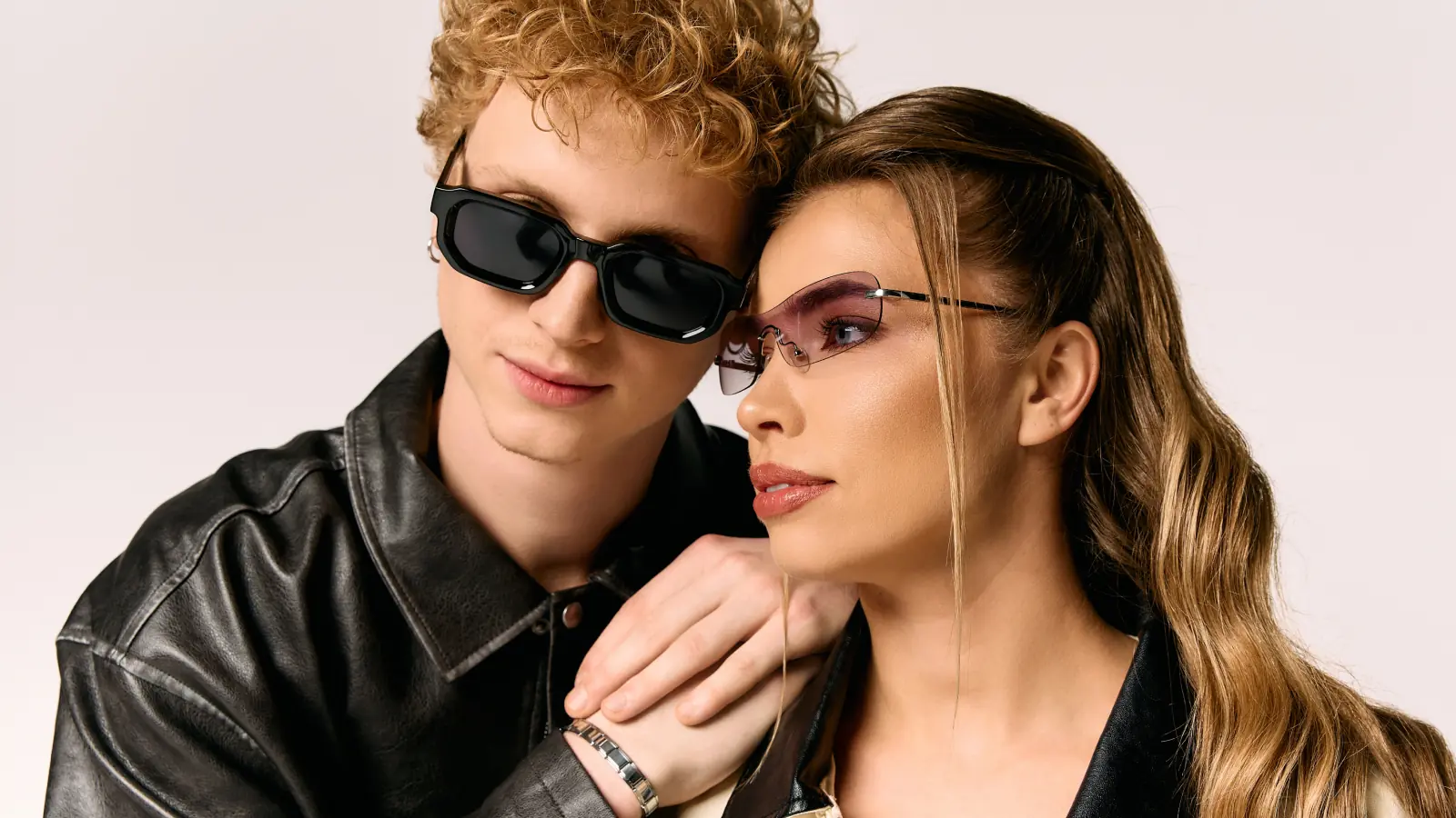 Trendy man and woman standing side by side in stylish outfits, showing modern couple fashion and confident vibes