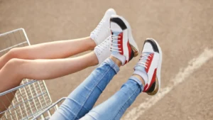Two young women in casual sneakers walking side by side, showing their legs and stylish shoes in a relaxed, modern setting.