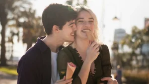 A young couple sharing a sweet kiss outdoors, capturing a tender and romantic moment filled with love and connection.