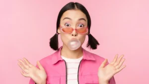 Portrait of a cheerful young woman with a bright smile, looking confident and happy, against a soft natural background.